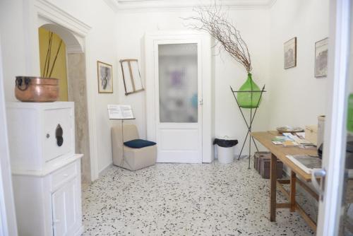 a room with a white door and a table and a desk at B&B Le Colonne in Brindisi