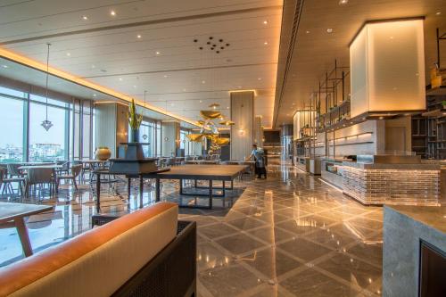 a restaurant with tables and chairs in a building at Pan Pacific Yangon in Yangon