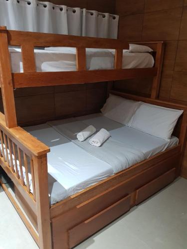 a wooden bunk bed with two white towels on it at Recanto Convenções in Olinda