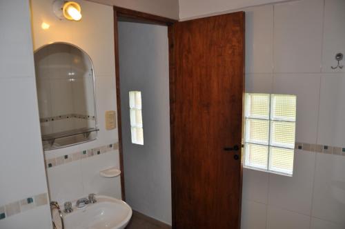 a bathroom with a sink and a wooden door at Cabañas Los Viñedos in San Rafael