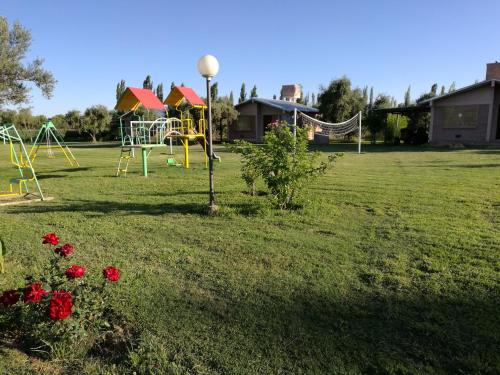 a park with playground equipment in the grass at Cabañas Los Viñedos in San Rafael