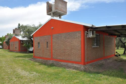 a red building with a cross on top of it at Cabañas Los Viñedos in San Rafael
