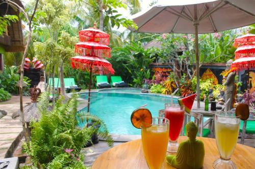 - une table avec des boissons à côté de la piscine dans l'établissement L'Bulu Menjangan, à Banyuwedang