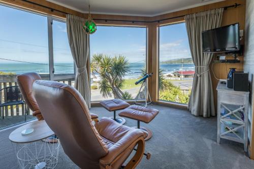 a living room with a view of the ocean at Kaka Point Spa Accommodation - Catlins in Kaka Point
