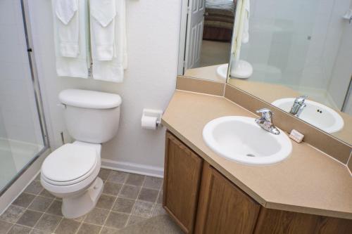 a bathroom with a toilet and a sink and a mirror at Almaton Loop Condo #239976 in Orlando
