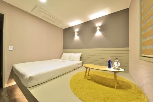 a small bedroom with a bed and a table at With U Hotel & Guesthouse in Sokcho