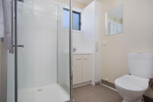 a bathroom with a toilet and a glass shower at Portland Holiday Village in Portland