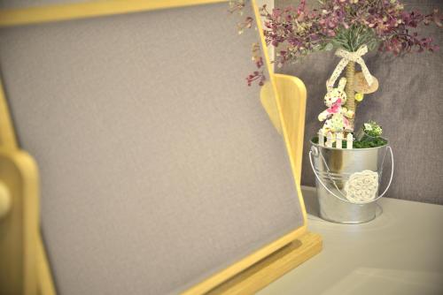 a sign on a table with a potted plant and a pot of flowers at With U Hotel & Guesthouse in Sokcho
