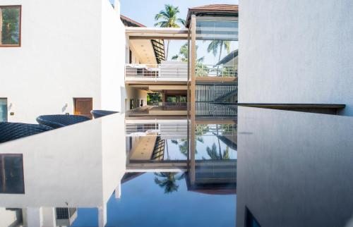 an external view of a building with its reflection in the water at The Ivy Anjuna in Anjuna