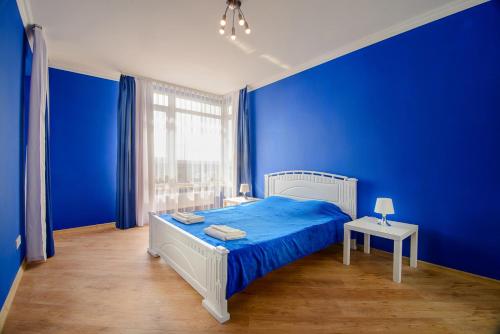 リヴィウにあるModern apartment in 10 min from city centerの青い壁のベッドルーム(白いベッド1台付)