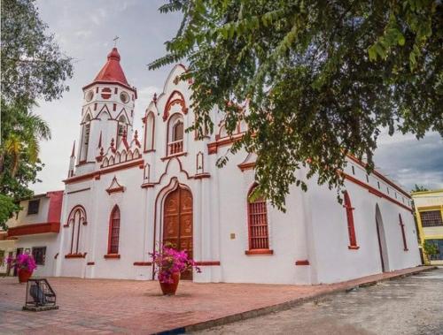 una grande chiesa bianca con torre dell'orologio di Casa Turística Realismo Mágico a Aracataca