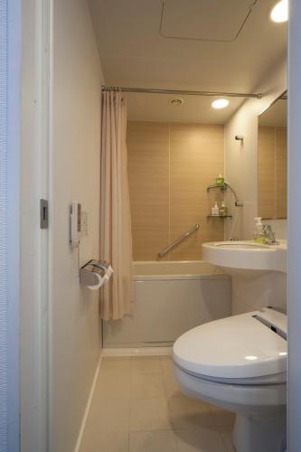 a bathroom with a toilet and a tub and a sink at Hotel Granvia Osaka-JR Hotel Group in Osaka