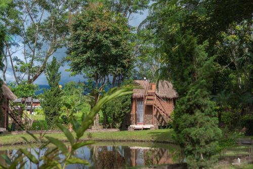 an old house with a thatched roof in a forest at The Countryside Pai in Pai