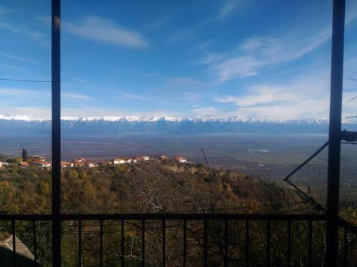 a view of snow covered mountains from a window at Guest House Aisi in Sighnaghi