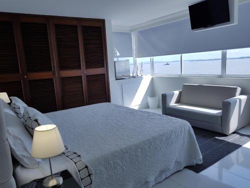 1 dormitorio con 1 cama, 1 silla y TV en Espectaculares Vistas, Edificio Nautilus, Barrio El Laguito., en Cartagena de Indias