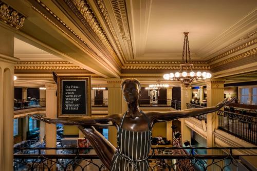 a statue of a woman in the lobby of a hotel at Treasury on Collins Melbourne in Melbourne