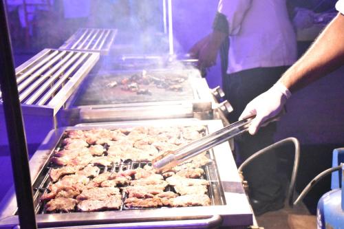 a person is cooking food on a grill at The Long Beach Resort & Spa in Koggala