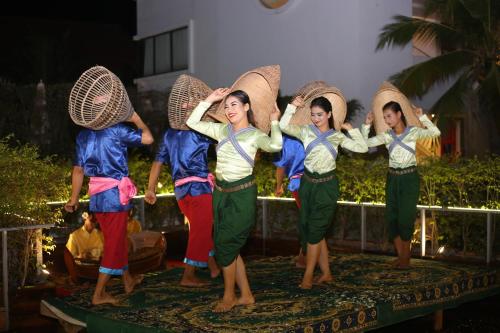 a group of women standing on a stage with umbrellas at Damrei Residence & Spa in Siem Reap