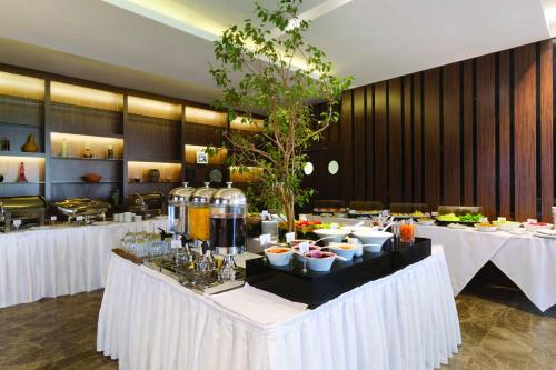 un ristorante con tavoli bianchi con sopra cibo di Ramada by Wyndham Istanbul Florya a Istanbul