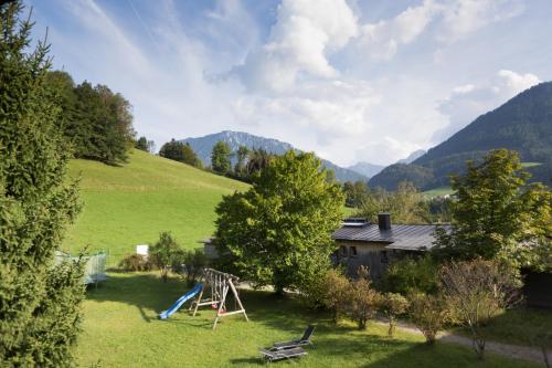 a yard with a playground and a house at Landhotel Maiergschwendt inkl Chiemgaukarte in Ruhpolding