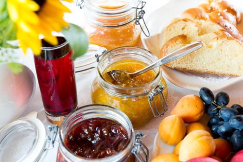 a table topped with jam and bread and fruit at Hotel Teichwirt in Fladnitz an der Teichalm