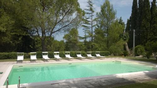 a swimming pool with lounge chairs and a group at Villa degli Scoiattoli in SantʼElpidio a Mare