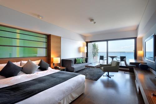 ein Schlafzimmer mit einem großen Bett und einem großen Fenster in der Unterkunft Scapes The Suite in Hayama