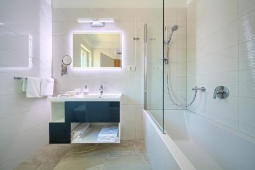 a white bathroom with a sink and a shower at Villa Adriana in Risika