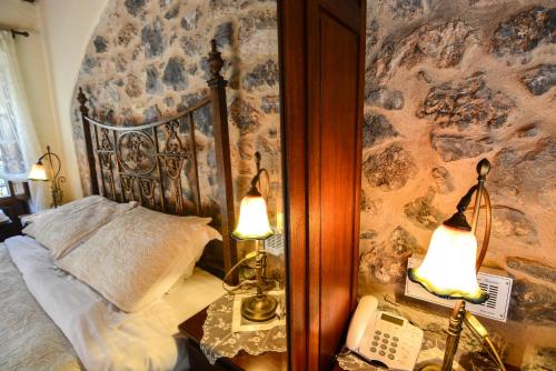 a bedroom with a bed and two lamps and a phone at Arhontiko Kefalari in Kefalari