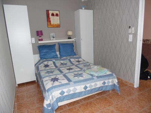 Cette petite chambre comprend un lit avec des oreillers bleus. dans l'établissement Meuble de la Tour, à Nogent-sur-Seine