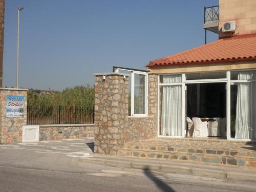 a brick house with a window with a white curtain at Kostas Studios in Faliraki