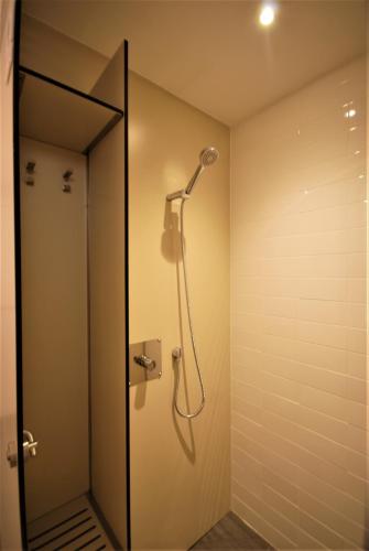 a shower in a bathroom with a mirror at Ten To Go Hostel in Barcelona