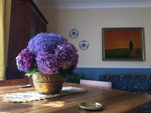 a vase filled with purple flowers on a table at Iride Bed and Breakfast in Baronissi
