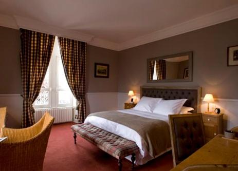 a bedroom with a large bed and a mirror at Le Petit Hôtel des Hortensias in La Trinité-sur-Mer