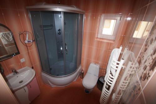 a bathroom with a shower and a toilet and a sink at Panorama Yasinya in Yasinya