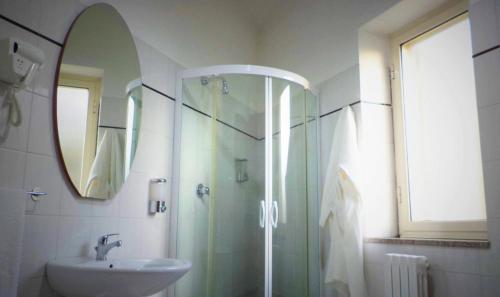 W łazience znajduje się szklana kabina prysznicowa i umywalka. w obiekcie Il Girasole w mieście Vibo Valentia