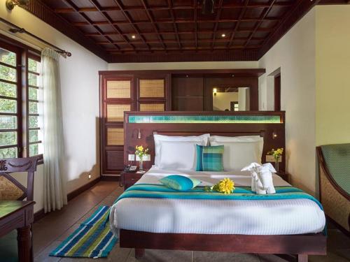 a bedroom with a large bed with a wooden headboard at Indriya Sands in Cherai Beach