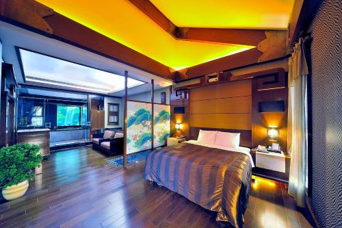 a bedroom with a bed and a yellow ceiling at Hakodate Motel in Kaohsiung