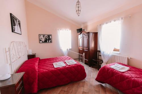 een slaapkamer met 2 bedden en rode lakens. bij Agriturismo Il Riccio in Monticchio