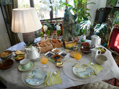 a table with breakfast foods and a lamp on it at Lou Amourie in Roussillon