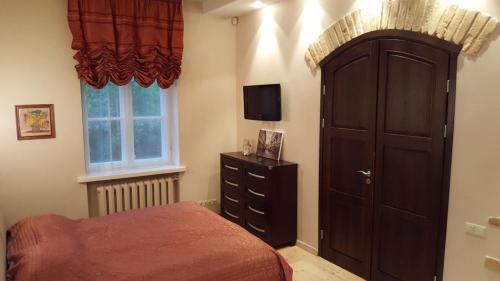 a bedroom with a bed and a cabinet and a television at Asmenos apartamentai in Vilnius