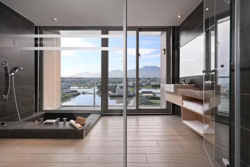 bagno con doccia e vasca con vista di Dancewoods Hotel a Wujie