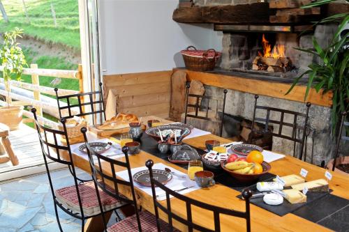a wooden table with food on it with a fireplace at Les chambres et Roulottes des Noisetiers in Leysin
