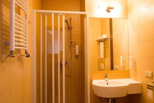 W łazience znajduje się umywalka, prysznic i umywalka. w obiekcie Kukubara Bowling Center w mieście Myszków