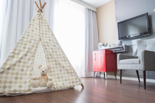a teddy bear sitting in a teepee tent in a living room at Mercure Sao Paulo Vila Olimpia in São Paulo