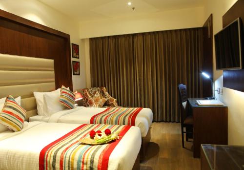 a hotel room with two beds and a desk at Hotel WJ Grand in Jalandhar