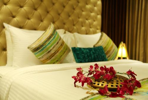a hotel room with a white bed with flowers on it at Hotel WJ Grand in Jalandhar