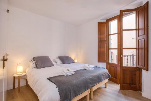 ジローナにあるFlateli Cort Reialのベッドルーム(大きな白いベッド1台、窓付)