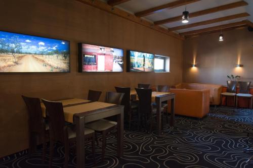 a restaurant with tables and chairs and televisions on the wall at Kukubara Bowling Center in Myszków