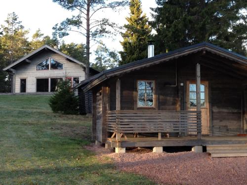 uma cabana de madeira em frente a uma casa em Rundbergs Stugor em Kungsö